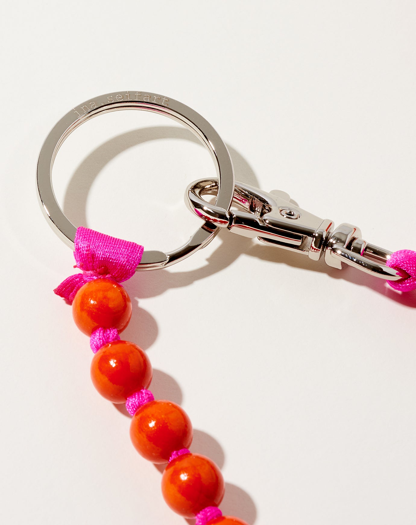 Ina Seifart Perlen Long Keyholder in Orange on Pink